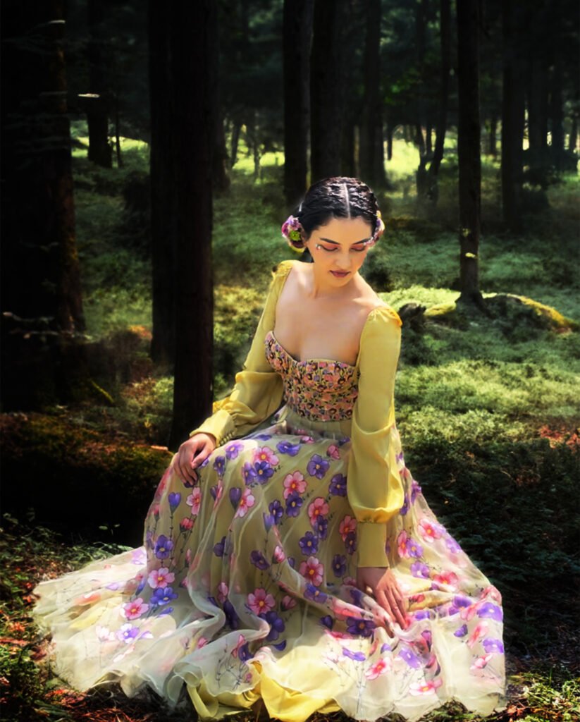 Woman in floral yellow and purple traditional outfit standing in forest setting, fashion brand photography, baavli