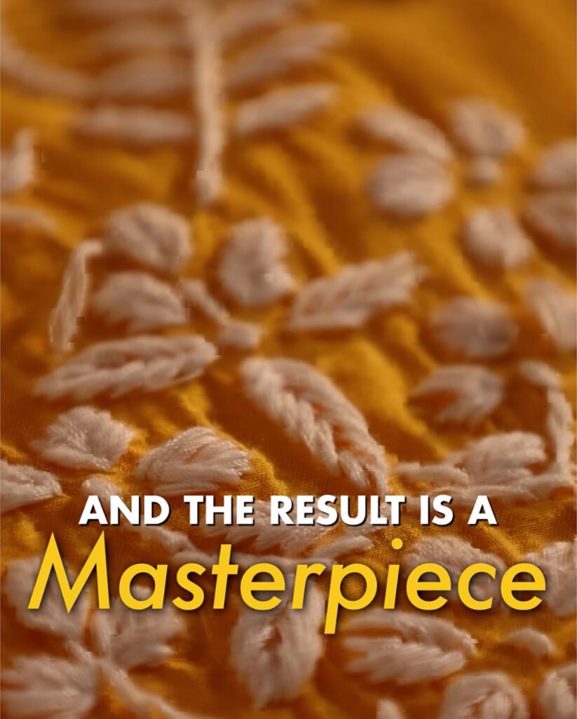 Close up of golden embroidered fabric texture with and the result is a masterpiece text overlay