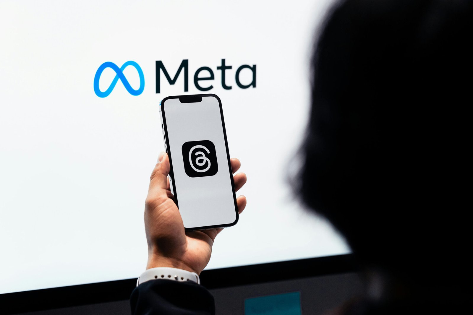Hand holding phone showing Meta Threads app, performance marketing on Meta platforms